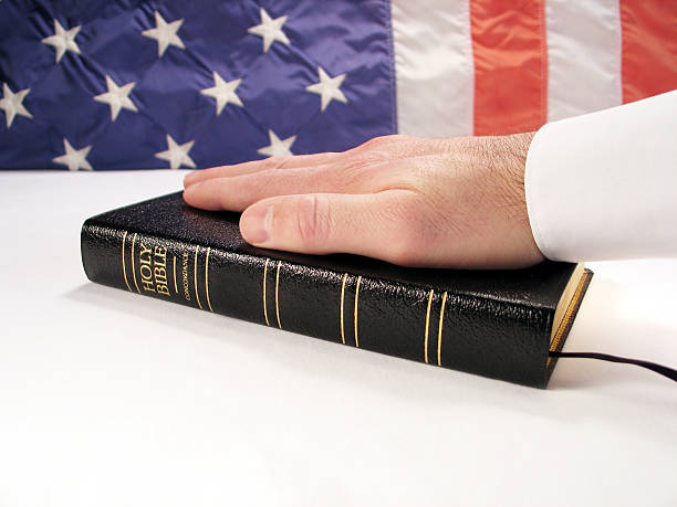 istock Inauguration Concept: Hand on Bible with American Flag Background 172217678