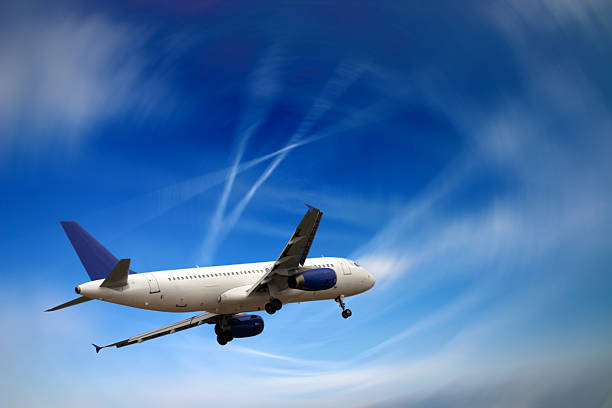 istock White airplane flying in a blue sky that's somewhat blurry 172217979