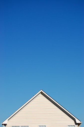 Plain white generic house with plenty of blue sky above.