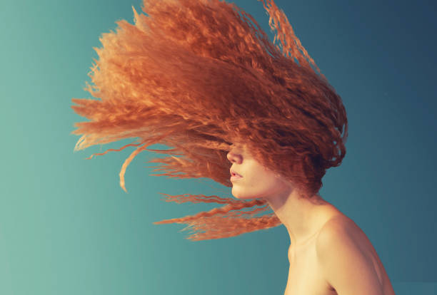 young woman with flying hair stock photo