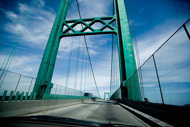 istock Turquoise suspension bridge against blue sky and wispy cloud 172220511