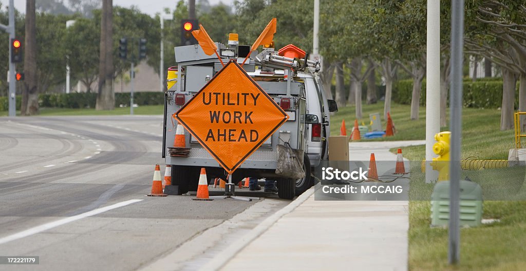 UTILITY CREW A utility crew works on the side of the road. Sewage Stock Photo