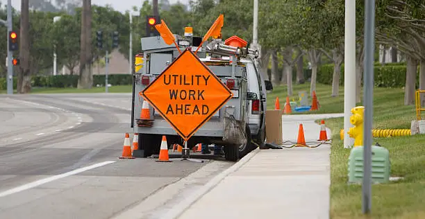 A utility crew works on the side of the road.