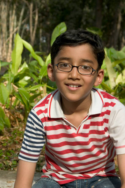 istock Young cheerful Indian boy looking at camera sitting in Park 172221676
