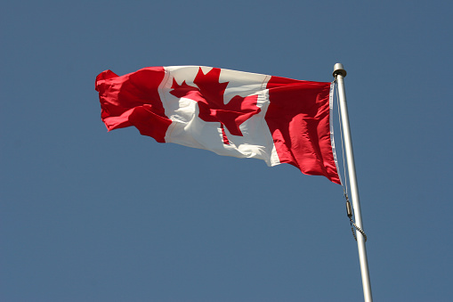 Canadian flag with blue sky.
