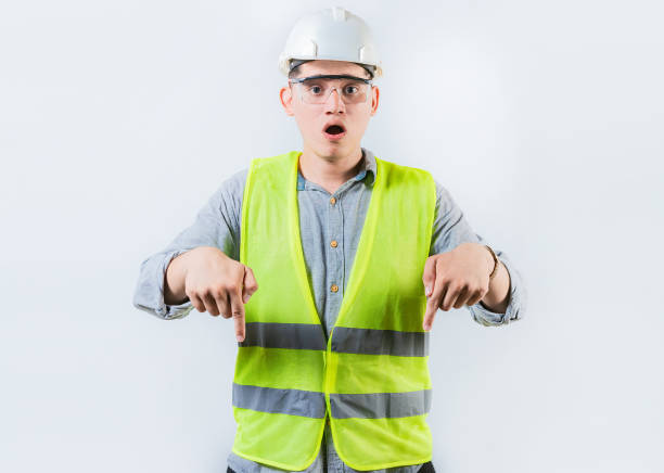 istock Surprised engineer pointing down advertising space isolated. Astonished male engineer pointing down an advertising space 1722224391