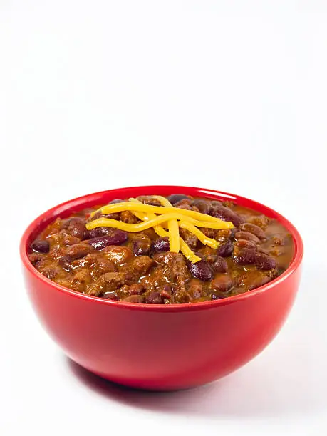 A hot generous helping of fresh homemade spicy chili with beans, hearty beef, sweet onion, and fresh tomato topped with shredded cheddar cheese.