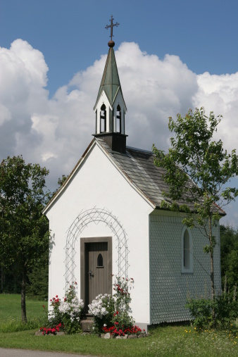 White Church in the meadow in front of a cloudy sky