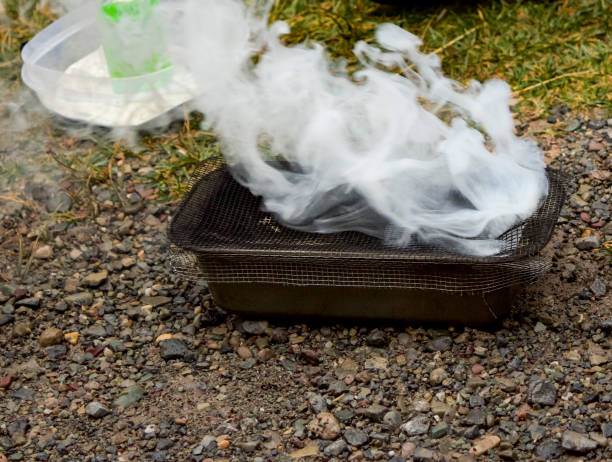 An on ground demonstration of how plastic spheres are activated for use in wild fire control.  The round spheres contain potassium permanganate.  Before dropping from the helicopter, they move through a tube and are injected with a green water and glycol solution, making the spheres combustable.  The exact combination of chemicals in each sphere determines how long it will take to ignite and how intensely the fire will burn.  From helicopters, they are dropped onto the ground to initiate a controlled burnout to remove debris from the ground - becoming a fire control line in that area.