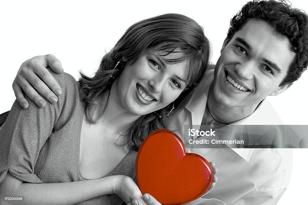 Beloved with a heart A young smiling couple with a nice red heart in their hands. Adolescence Stock Photo