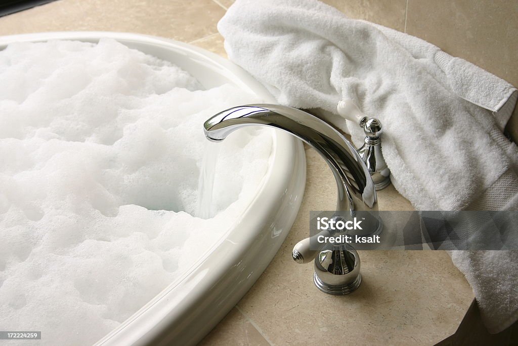 Bagno schiuma con rubinetto Cromato, asciugamano, color travertino - Foto stock royalty-free di Vasca da bagno