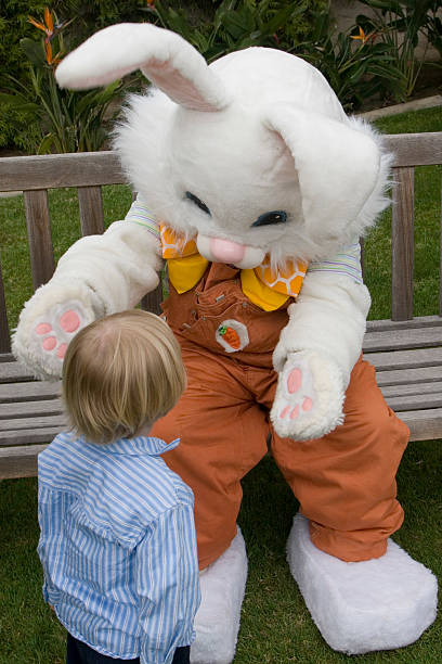 Young child walking up to Easter bunny stock photo