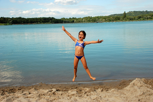 Jumping 5 year old girl at lake shore. Please see similar pictures from my portfolio:
