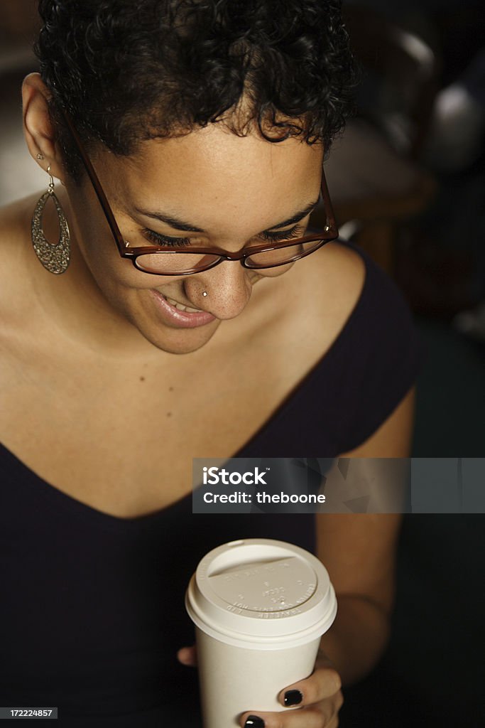 Mujer joven mirando hacia abajo con café - Foto de stock de 20 a 29 años libre de derechos