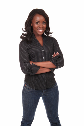 Photo of an attractive young woman standing with her arms folded.