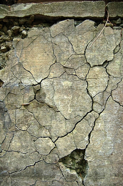 Close up from above of cracks in grey concrete stock photo