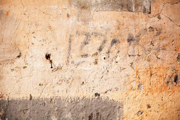 dirty wall with paint numbers and a rusty nail stock photo