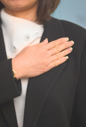Upclose shot of a woman taking a pledge. Low depth of field focus on the hand.