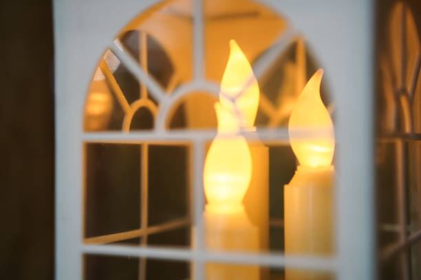 istock Artificial candles lit behind white framed windows. Candles inside hanging small transparent box for room or wedding party decor 1722271852