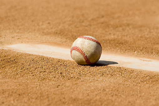 A baseball sitting on the pitchers mound.