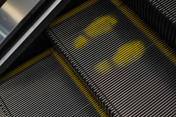 istock Yellow footprints on the escalator steps in the shopping mall. Automatic escalator in the subway. 1722279018