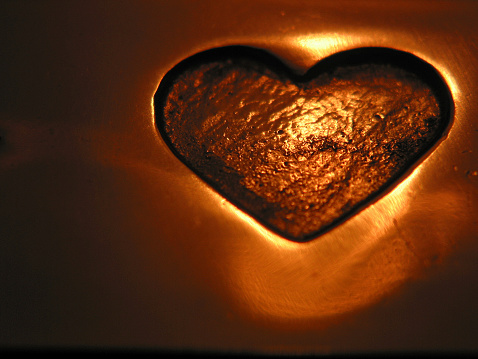 A heart stamped into polished copper metal. (Also looks great in different color hues).
