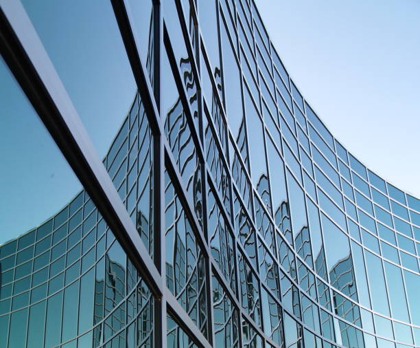 Geometrical Office Space Geometrical design in office building windows.  Curved building reflecting itself in blue and green. skyscraper office building built structure new york city stock pictures, royalty-free photos & images