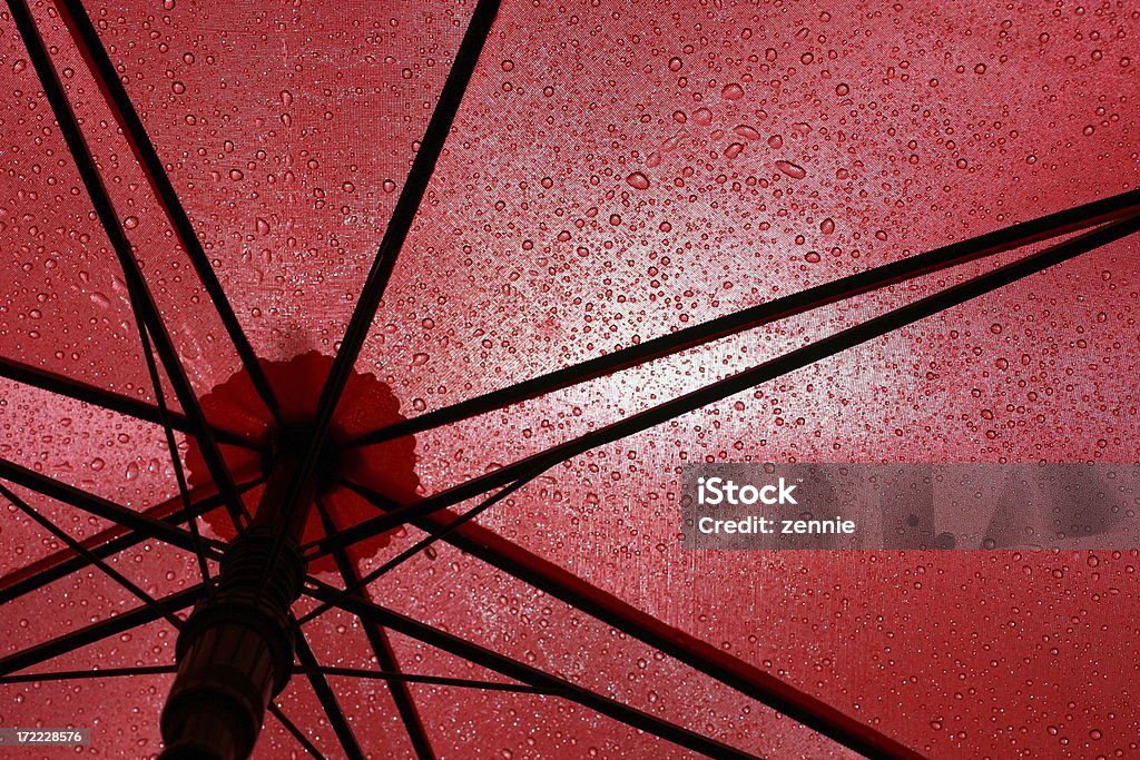 Under A Red Umbrella Under the shelter of a wet umbrella on a rainy day. Backgrounds Stock Photo