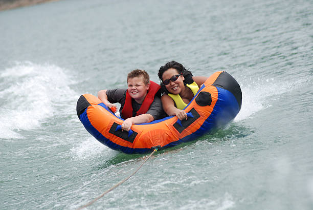 sorridente sulla cannula interna - water sport family inner tube sport foto e immagini stock