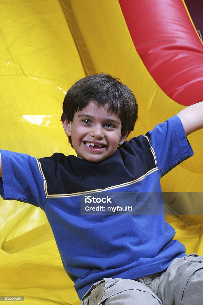 Ragazzo su scivolo gonfiabile sorrisi - Foto stock royalty-free di Arto - Parte del corpo