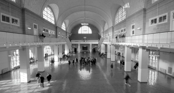 Black and White photo of the great hall in the Ellis Island Immagration museum.