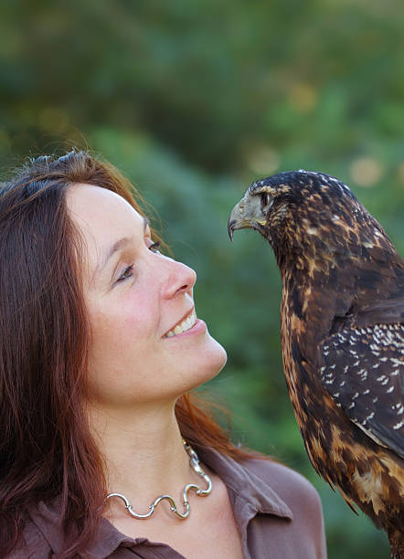 woman with eagle portrait of a woman with a black chested buzzard eagle young black chested buzzard eagle geranoaetus melanoleucus stock pictures, royalty-free photos & images