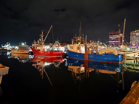 Fishing boats moored at Hobart's harbour by night, Tasmania, Australia.