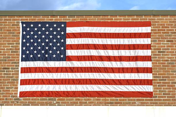 Prominently mounted flag on local industry brick wall.