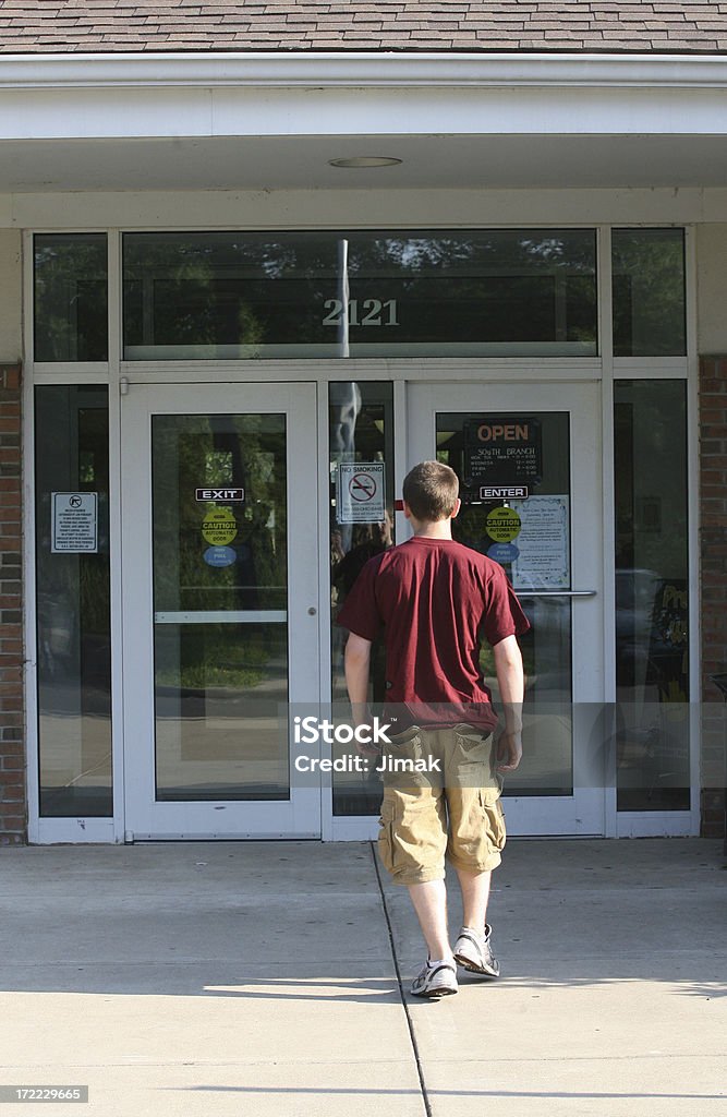 Adolescente maschio approcci business ingresso. - Foto stock royalty-free di Entrare
