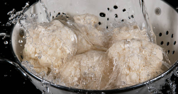 istock Water falling on Cauliflower, brassica oleracea, against Black Background 1722306768