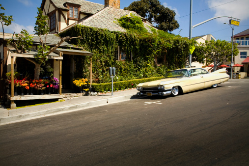 Cool street corner with an old car and building.