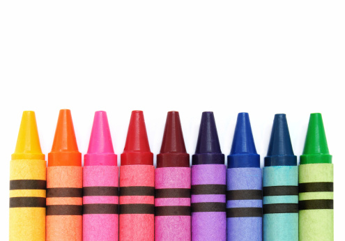 Multicolored crayons lined up on white background. Group of crayons of different colors.