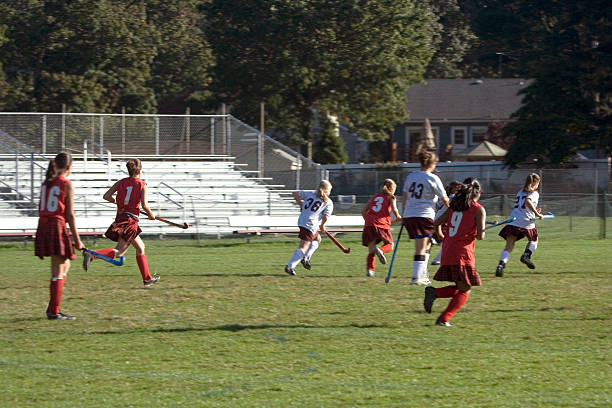 High school girls playing field hockey on a late afternoon in autumn.Shot with motion blur.