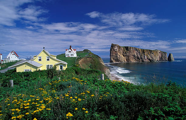 Houses on the coast of Perce, Quebec, Canada  Perce rock is a huge sheer rock formation in the Gulf of Saint Lawrence on the tip of the Gaspe Peninsula in Quebec, Canada, off Perce Bay. gulf of st lawrence photos stock pictures, royalty-free photos & images