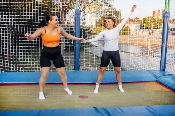 istock Two girls having fun jumping on trampoline in public park 1722326882