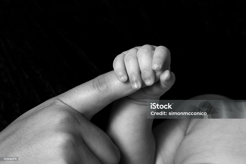 Black and white of a baby's hand holding his mom's finger A baby holding their parents hand Baby - Human Age Stock Photo