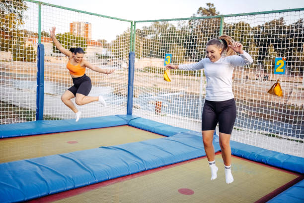istock Two girls having fun jumping on trampoline in public park 1722328543