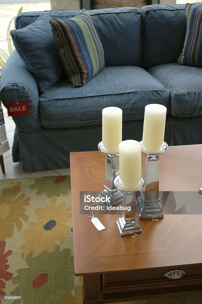 Home Furnishings "Candles, coffee table, couch, and rug in a home furnishings store." Blue Stock Photo