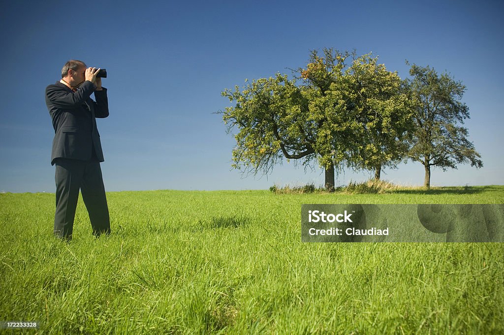 Business man in a field Business man outdoor, see other pics of that model: Binoculars Stock Photo