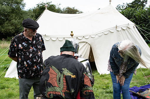 Kenilworth England  July  29th  2023  Two visitors  watch  a  knight  being  armed  ready  for the tournament