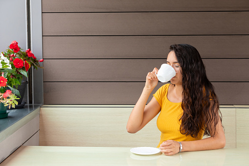 Latin woman drinking coffee in cafe