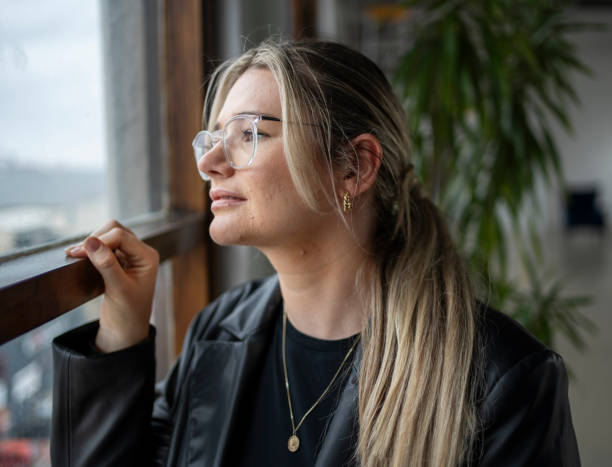 istock Thoughtful young woman looking out of a window 1722351532