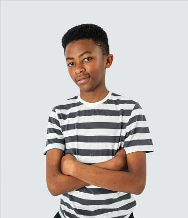 Portrait of a confident teenage african boy standing with arms crossed over white background