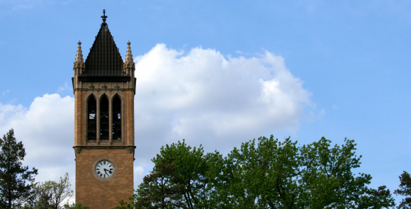 A landscape image of a clock tower on a college campus.